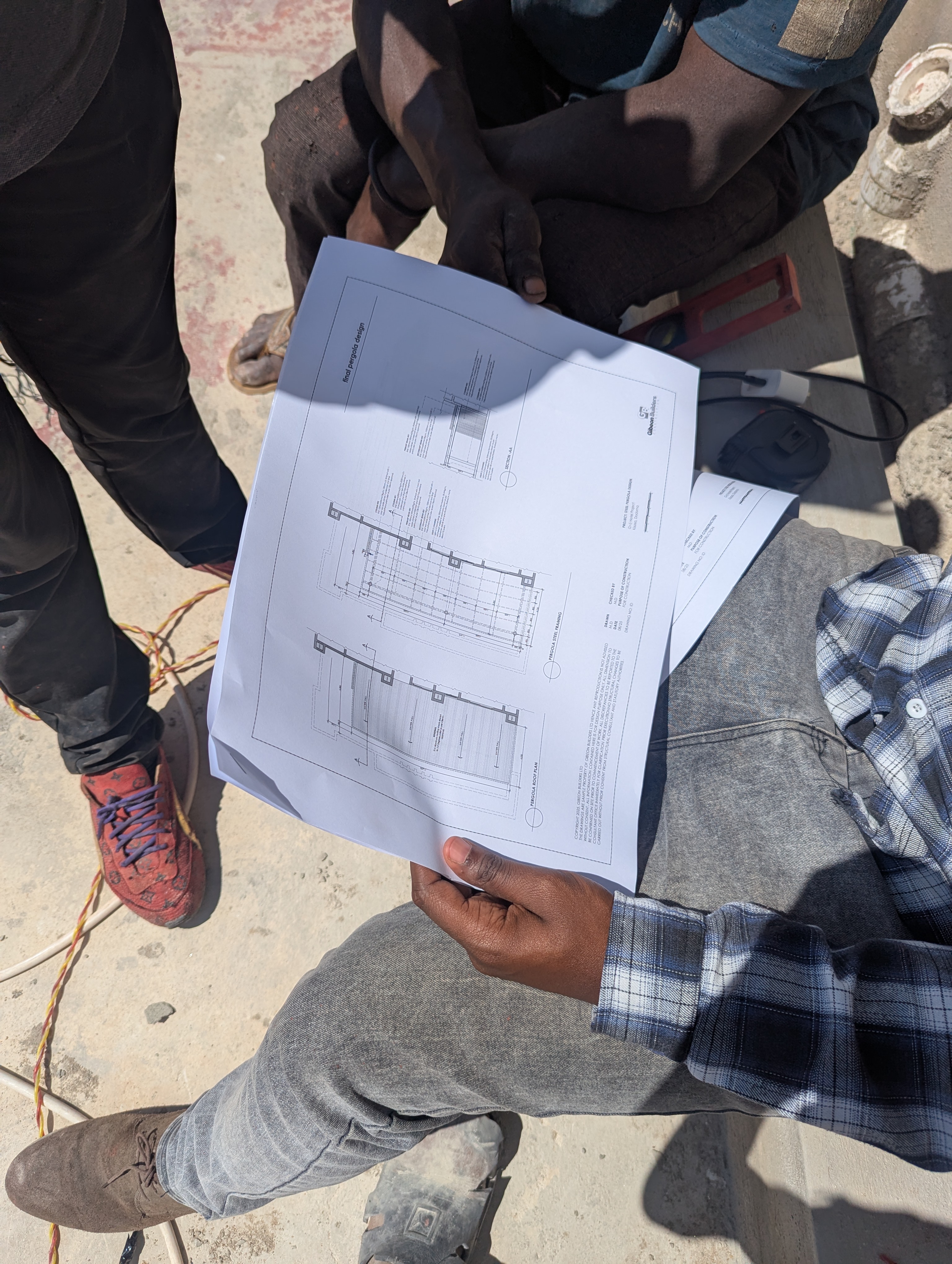 Gibeon Builders team reviewing blueprints on site